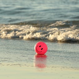 Ein Smiley Ball am Strand