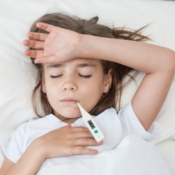 Krankes Kind liegt im Bett mit Fieber