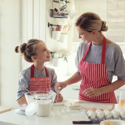 Frau mit Mädchen beim Backen