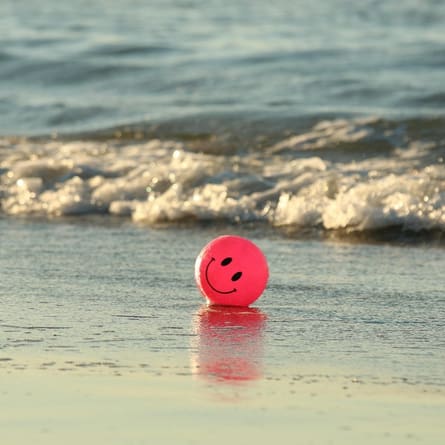 Ein Smiley Ball am Strand