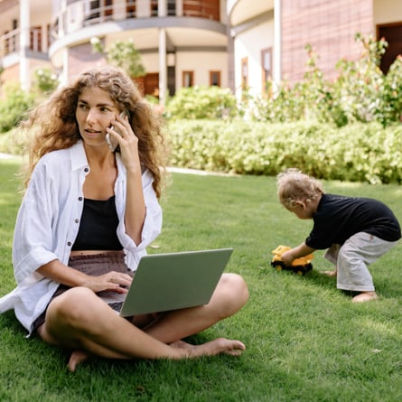 Arbeitende Mutter im Freien mit spielendem Kind