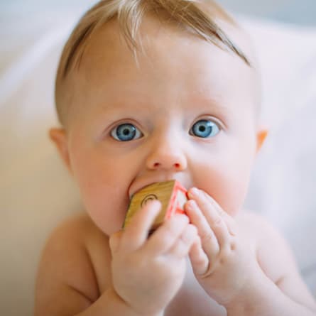 Baby mit einem Holzspielzeug