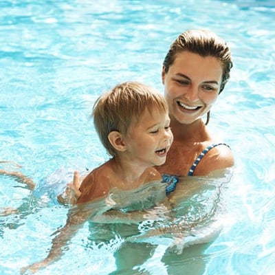 Mutter mit kleinem Kind im Freibad.